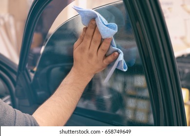 Worker Polishing Tinted Car Window