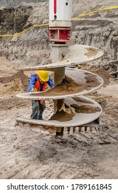 Worker Positioning A Drilling Work Tool To Bore A Earth Tunnel 
Close-up Of A Drilling Spindle Or Auger Tool Used In Construction Sites