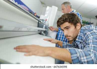 worker at a post press finishing line machine