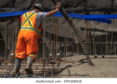 Worker Pours Concrete On Construction Site