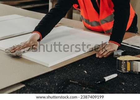 A worker prepares PVC furniture boards for packaging. Close-up. Furniture manufacturing