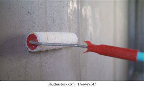 A Worker Primers The Walls With A Brush. Wall Painting With Primer Paint With A Large Brush