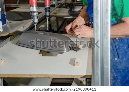 Worker in production. Production of street lanterns. Machine