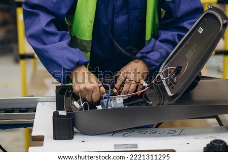 Worker in production. Production of street lanterns. Machine