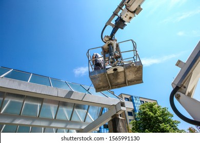 Worker Of Professional Facade Cleaning Services Washing A Galss Roof