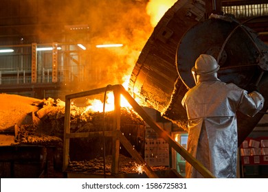 Worker In Protective Clothing Pouring Molten Metal In Foundry - Powered by Shutterstock