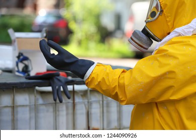 Worker With Protective Clothing Puts Gloves On