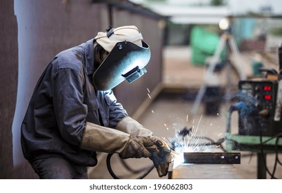 Worker with protective mask welding metal  - Powered by Shutterstock