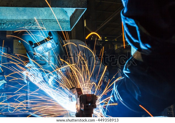Worker with protective mask welding\
metal, knowledge to take action Gas welding car\
industry