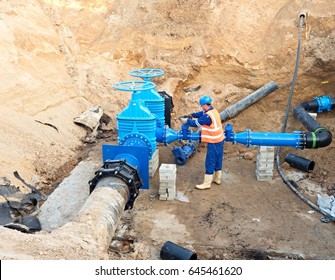 Worker in protective workwear underground on gate valve, reconstrucion of drink water system - Powered by Shutterstock