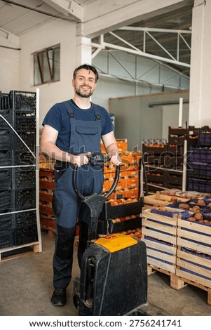 Worker pushing pallet jack in fruit warehouse