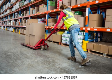 Worker pushing trolley with boxes in warehouse - Powered by Shutterstock