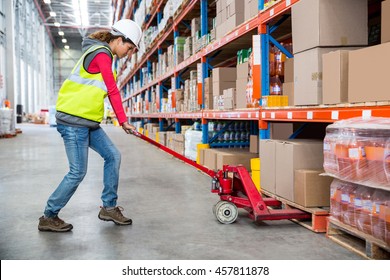 Worker pushing trolley with boxes in warehouse - Powered by Shutterstock