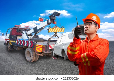 Worker With Radio Communication In Action For Working At Heavy Duty Truck Used For Towing Accident Saloon Car On The Road