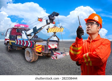 Worker With Radio Communication In Action For Working At Heavy Duty Truck Used For Towing Car On The Road