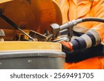 Worker refuels heavy machinery at a construction site during daylight hours