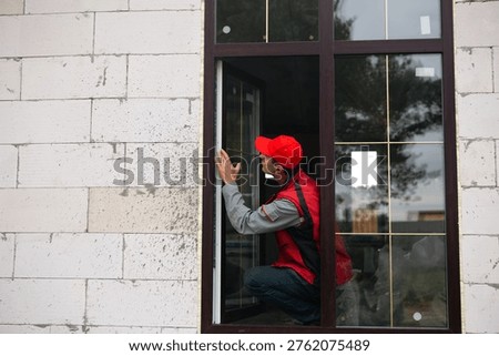 Worker regulates newly installed plastic window at home, ensures sealing and alignment, quality control by professional window installer, home renovation.