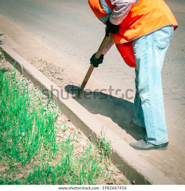 The\
worker removes dirt from the roads of the\
streets.