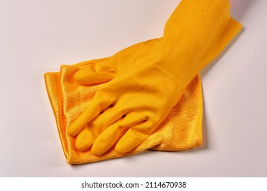 The Worker Removes Dust From The Furniture. Cleaning Service . A Hand In A Yellow Glove With A Dust Rag Close-up.