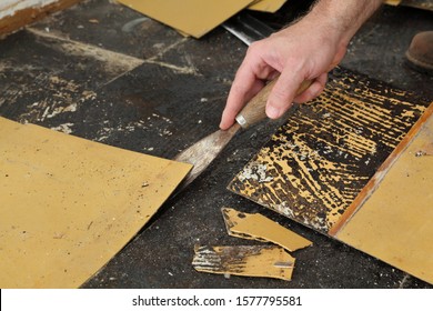 Worker Removing Old Vinyl Tiles From Kitchen Floor Using Spatula Trowel Tool