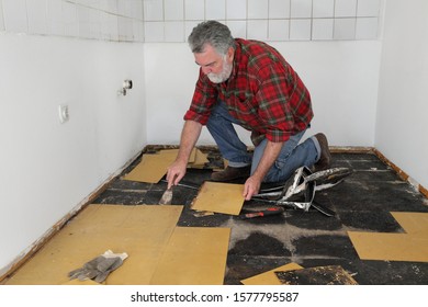 Worker Removing Old Vinyl Tiles From Kitchen Floor Using Spatula Trowel Tool