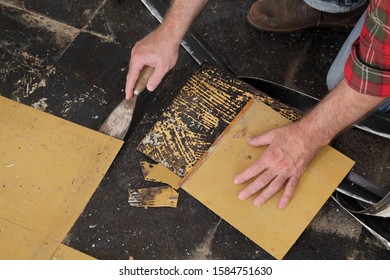 Worker Removing Old Vinyl Tiles From Kitchen Floor Using Spatula Trowel Tool