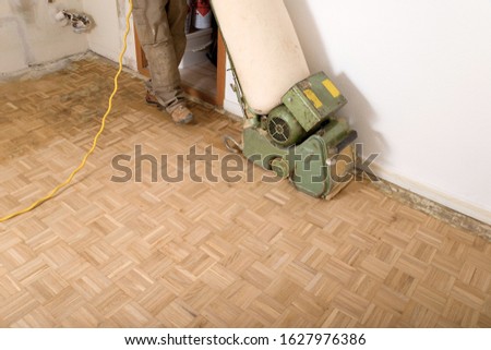 Worker renovating a parquet floor