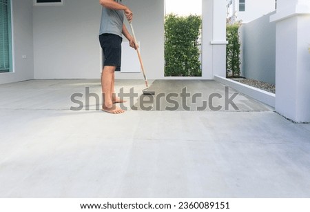 Worker and renovation work. To using roller painting mortar cement or finishing material for repair crack, skim coat or improvement surface of concrete pavement floor or slab for driveway or garage.