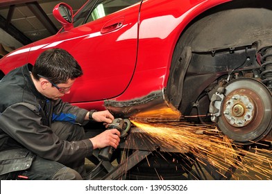 Worker repairing car body.