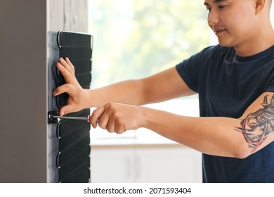 Worker Repairing Fridge In Kitchen