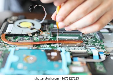 Worker is repairing to inside the laptop. The basic components of laptops function identically to their desktop counterparts. Traditionally they were miniaturized and adapted to mobile use. 
