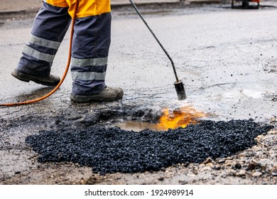 Worker Repairing Pothole With Bitumen Asphalt On The Road