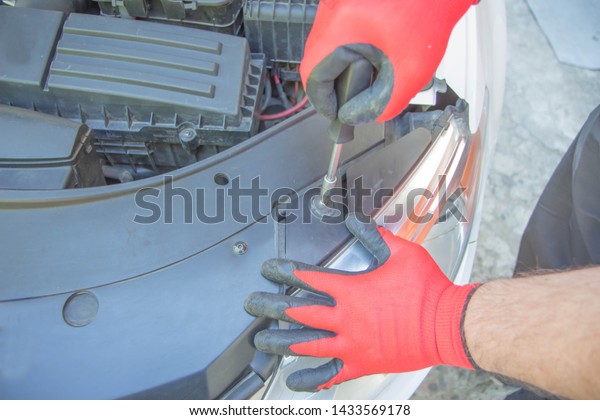Worker\
repairs a car in a car repair center. Repair service. Maintenance\
of automotive. The mechanic is repairing the\
car