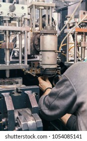 worker repairs a machine for plastic injection, close up