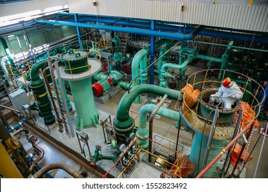 Worker repairs pipeline of water circulation in power plant.