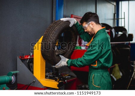Worker reparing tire in workshop