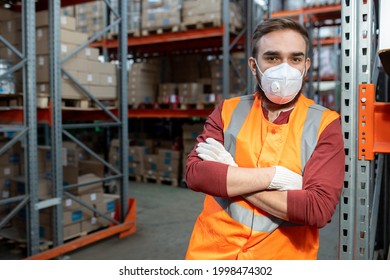 Worker In Respirator And Workwear Crossing Arms By Chest