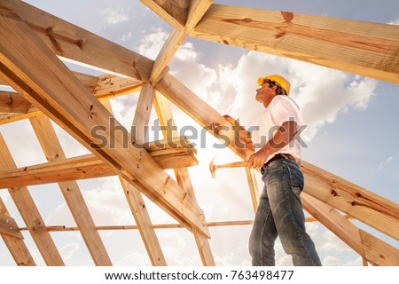 worker roofer builder working on roof structure on construction site
