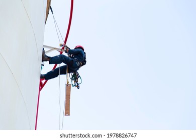 Worker Rope Access Inspection Of The Chemical Storage Tank Wall.