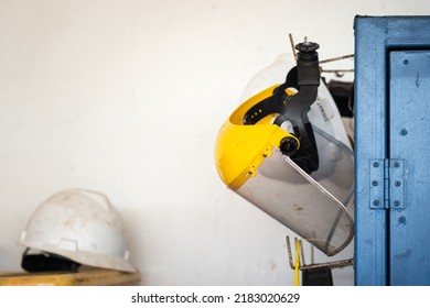 A Worker Safety Face Shield Is Keeping On Storage Rack.  Industrial Safety Equipment Photo. Close-up And Selective Focus, 