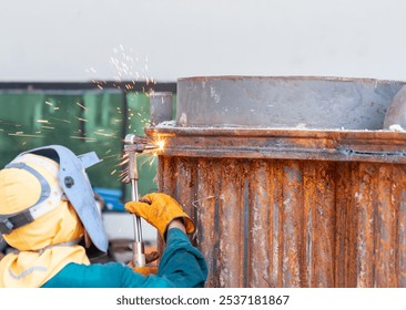 Worker in safety gear uses gas torch to cut metal on workshop. - Powered by Shutterstock