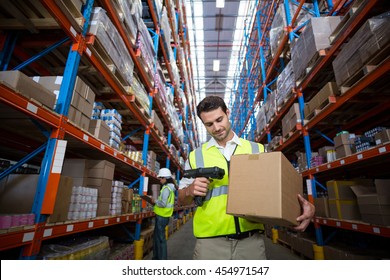 Worker Scanning A Box In Warehouse