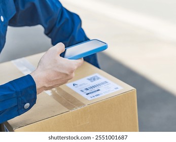 A worker scans the label on a package with his smartphone - Powered by Shutterstock