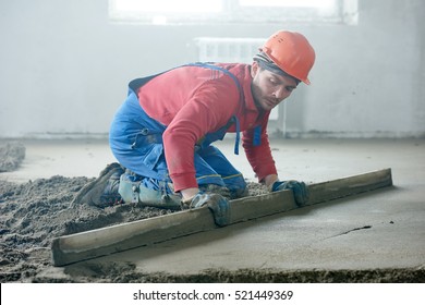 Worker Screeding Indoor Cement Floor With Screed