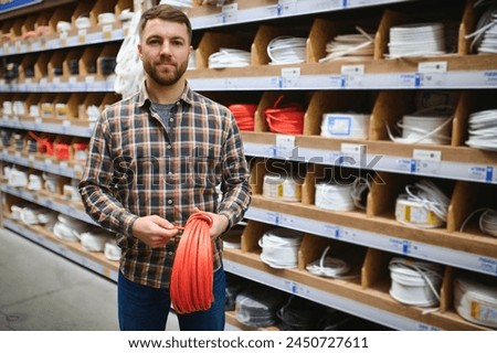 Worker selects an electrical cable at a hardware store.