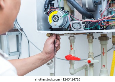 Worker Set Up Central Gas Heating Boiler At Home