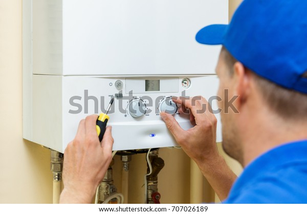 worker set up\
central gas heating boiler at\
home
