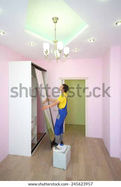 Worker Setting Mirrored Doors Sliding Wardrobe Stock Photo