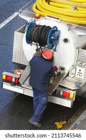 worker of sewer service company with  small  truck to unclog pipes in city