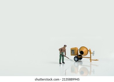 A Worker With Shovel In Front Of A Cement Mixer Isolated On White Background